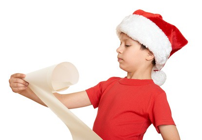 boy in red hat with long scroll wishes to santa - winter holiday christmas concept