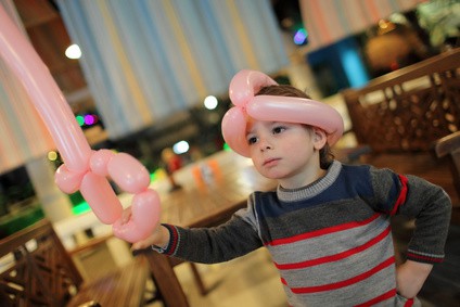 Child playing with balloon sword and helmet