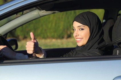 Happy arab saudi woman driving a car with thumb up