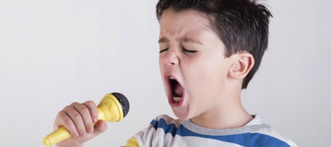niño cantando con un micrófono